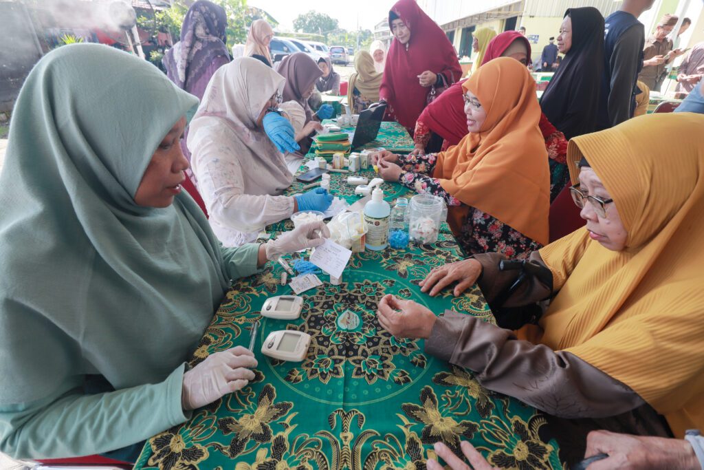 Petugas Kesehatan Putri melakukan Pemeriksaan kesehatan untuk Lansia Putri