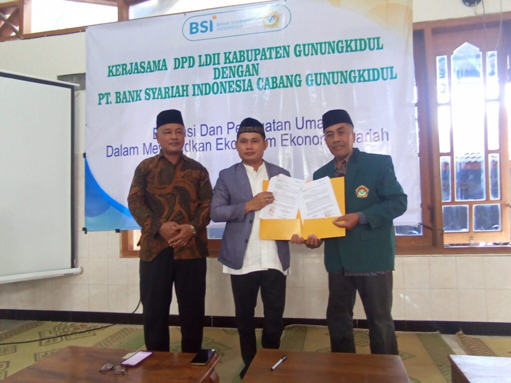 Ketua DPD LDII Gunungkidul dan Branch Manager BSI KCP Gunungkidul berfoto bersama dan menunjukkan hasil Nota Kesepahaman (MoU)
