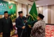 Ketua DPW LDII Babel terpilih, Supriyadi, menerima bendera panji organisasi dari Ketum DPP LDII. Foto: LINES