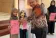 Syaquila Ravabia Fakhurriza saat menerima piala dan penghargaan dari Ketua Forum Komunikasi Madrasah Diniyah Takmiliyah (FKDT) Kabupaten Sleman, Mardiansyah