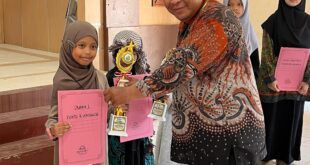 Syaquila Ravabia Fakhurriza saat menerima piala dan penghargaan dari Ketua Forum Komunikasi Madrasah Diniyah Takmiliyah (FKDT) Kabupaten Sleman, Mardiansyah