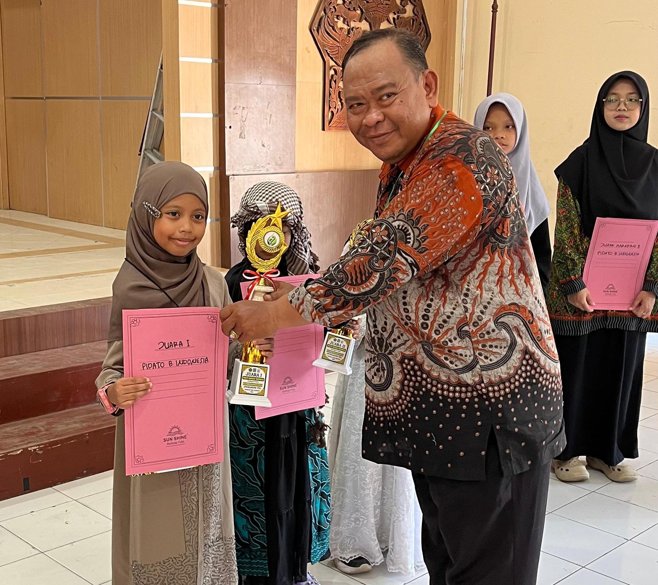 Syaquila Ravabia Fakhurriza saat menerima piala dan penghargaan dari Ketua Forum Komunikasi Madrasah Diniyah Takmiliyah (FKDT) Kabupaten Sleman, Mardiansyah